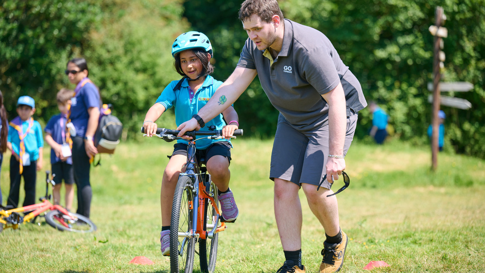 A beaver cycling with a go outdoors volunteer