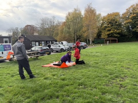 Scout volunteers taking part in an outdoor first aid training exercise at a Scout headquarters